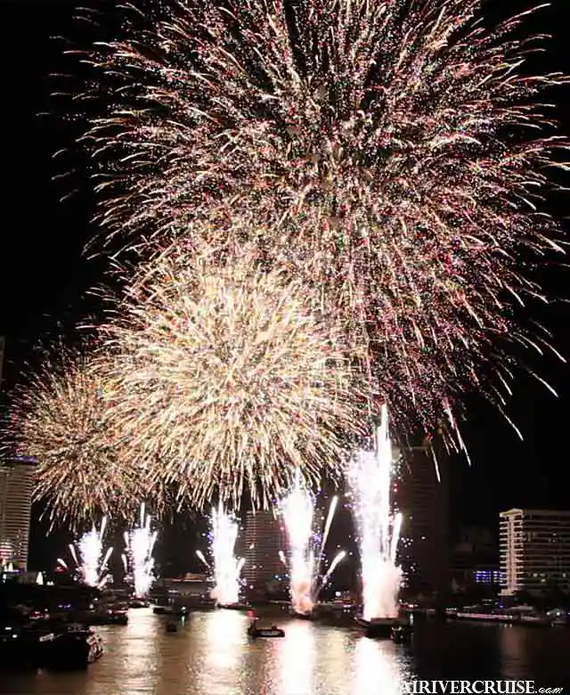 Midnight fireworks lighting up the sky over Bangkok's Chao Phraya River during New Year's Eve celebrations